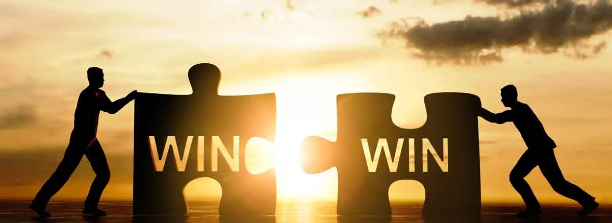 Das Bild zeigt Personen, die zwei Puzzlestücke mit der Aufschrift „Win“ zusammenschieben und verdeutlicht die Vorteile, die eine GbR-Gründung für die Gesellschafter hat. Idealerweise handelt es sich um eine Win-Win-Situation.
